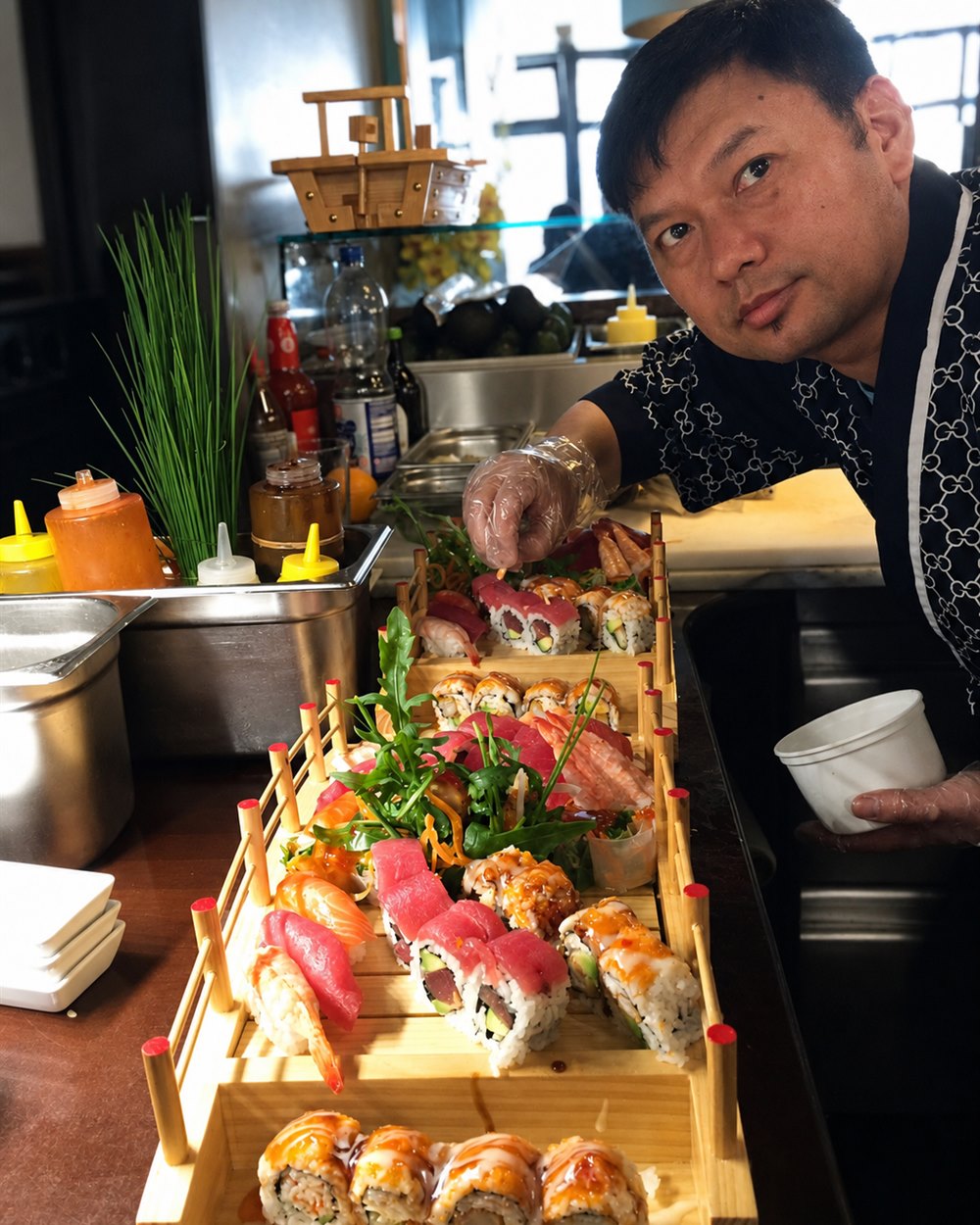 Sushi-Meister von Sushi & more richtet frische Sushi-Boote von Hand an